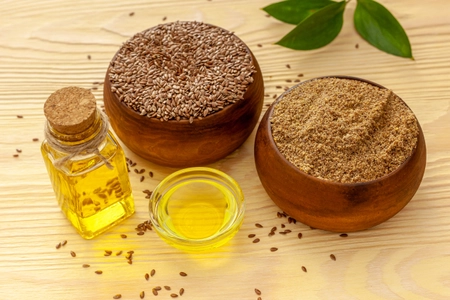 Flaxseeds and a bottle of flaxseed oil and flaxseed flour.