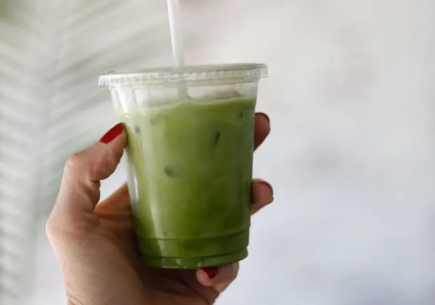 Hand holding a glass of green Vegetable juice