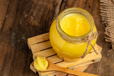 Homemade ghee Pure desi ghee in a bowl with wooden spoon
