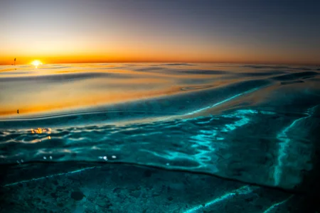 Sunset with golden light reflecting on the surface of the ocean.