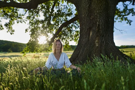 Woman meditating under a tree